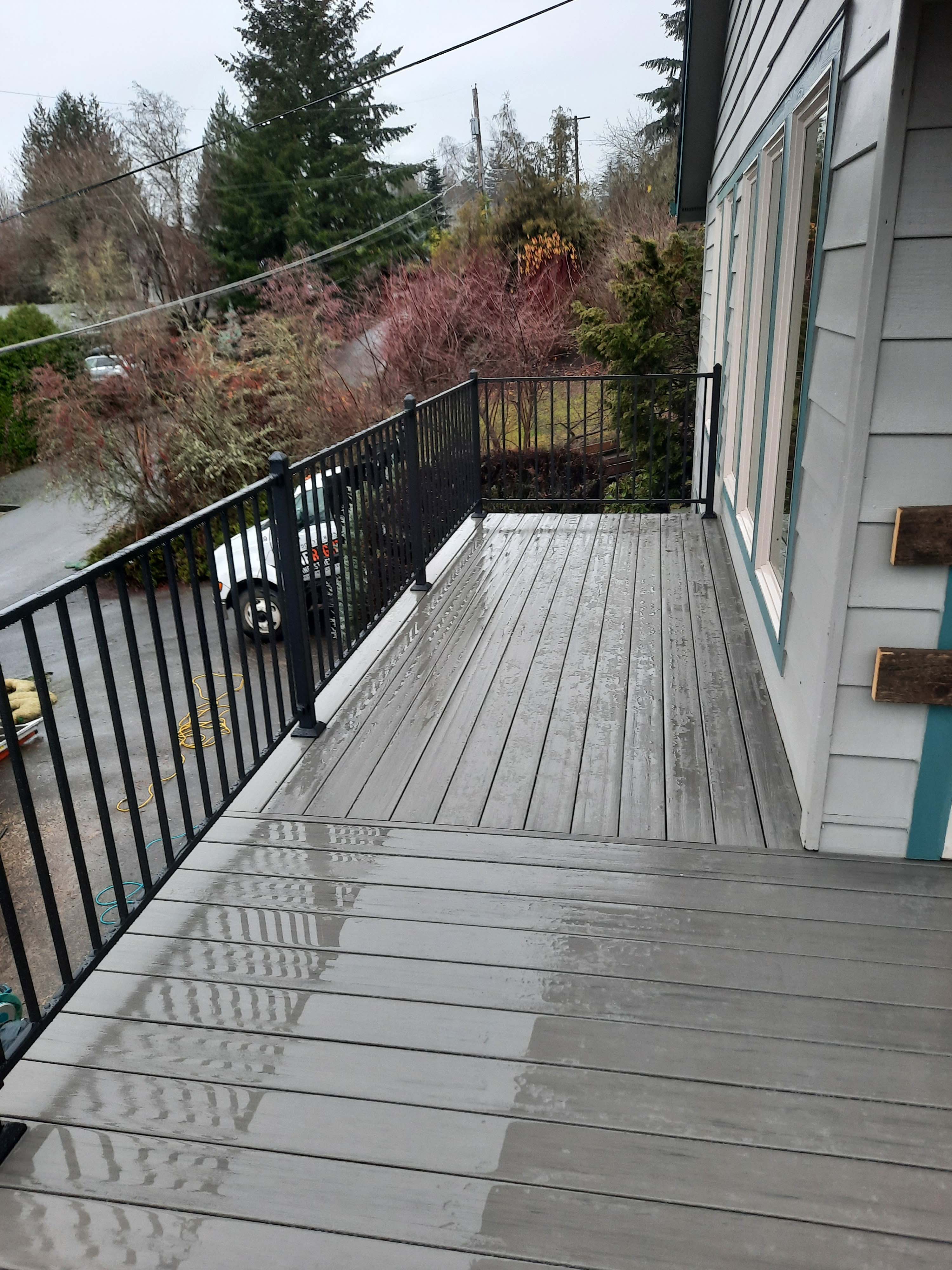 Remodeled wood deck with metal railings and gray colored planks