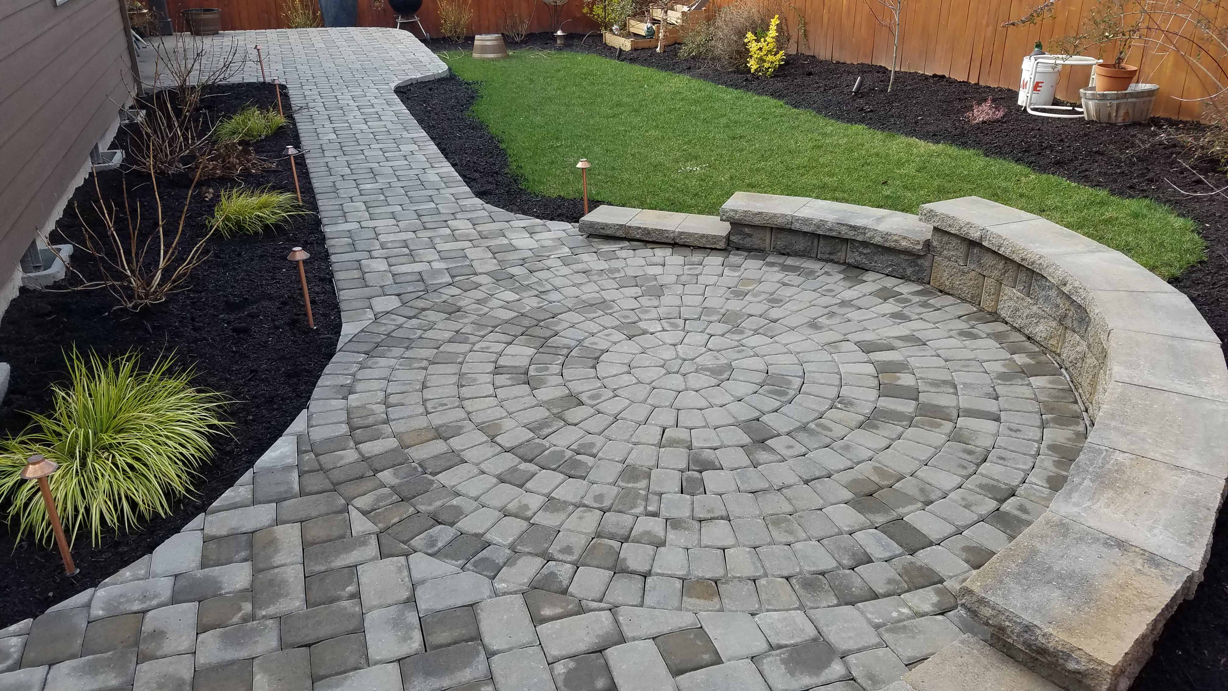Brand new stone pathed patio with new plants in mulched area