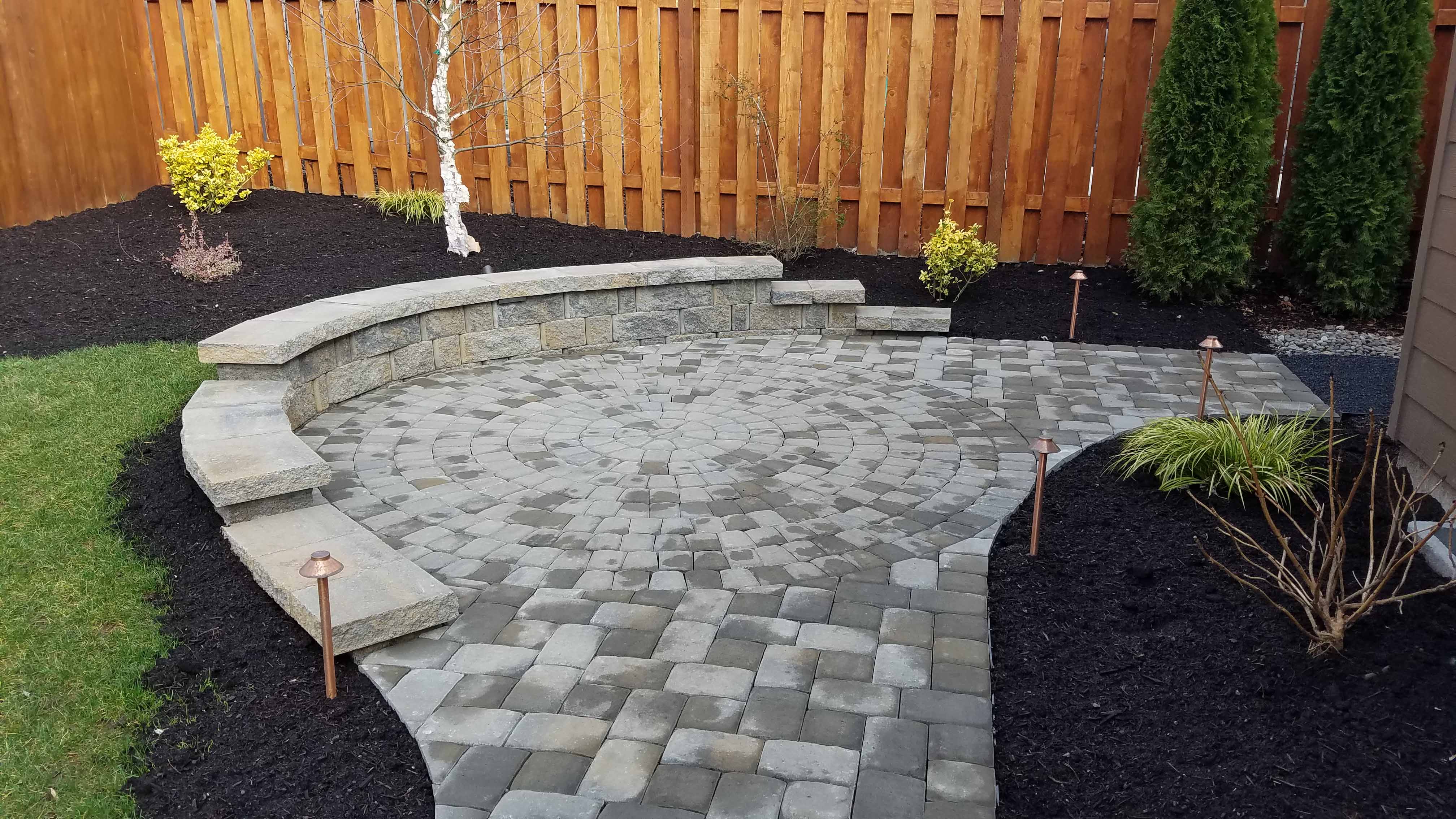 Brand new path and patio section with newly planted trees and plants