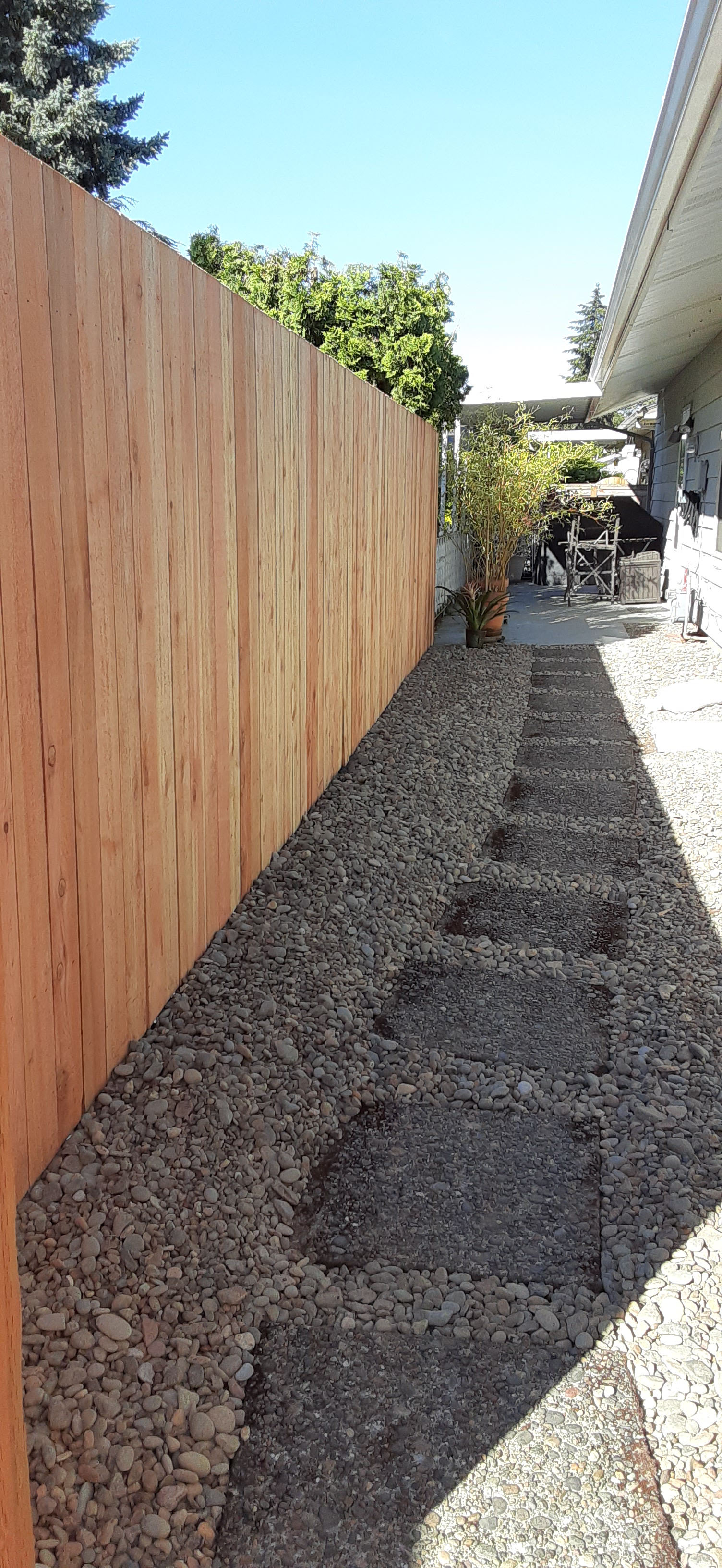 Brand new cement path with stone bed lining the entire side of the house