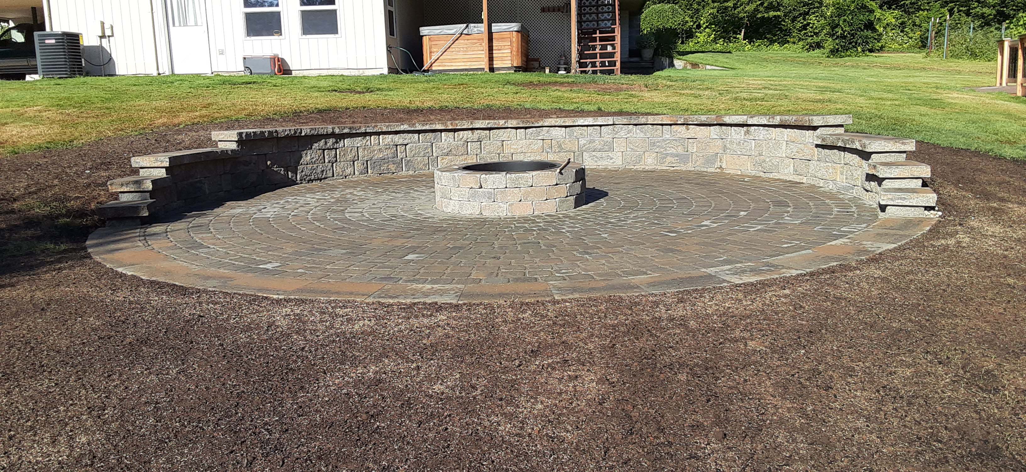 Large fire pit area with large brick retaining wall, big enough to sit plenty of people
