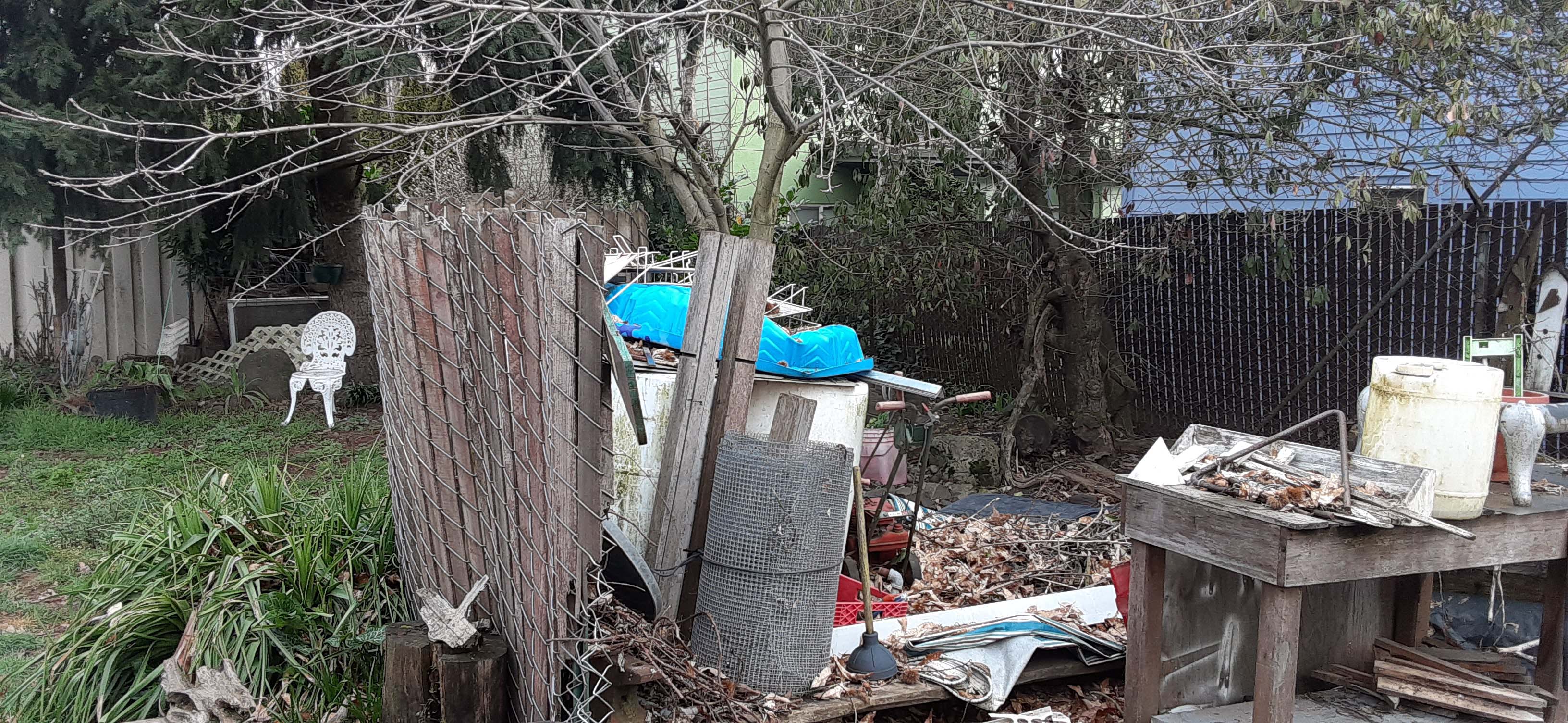 Trash and debris piled up in a backyard area
